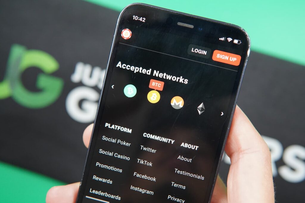 Patrik Lidin holding an iPhone with the BetcoinSocial casino payments page loaded on the webpage.