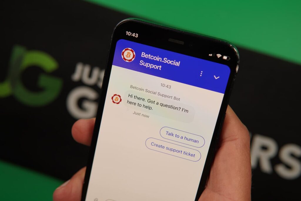 Patrik Lidin holding an iPhone with the BetcoinSocial casino support page loaded on the webpage.