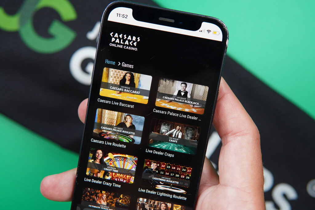 Photo of Patrik Lidin holding an iPhone with online live casino Caesars Palace showing.