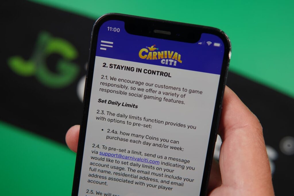 Patrik Lidin holding an iPhone with the Carnival Citi casino Responsible Gaming page loaded on the webpage.