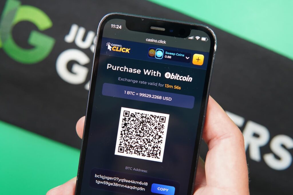 Patrik Lidin holding an iPhone with the Casino Click casino crypto purchases page loaded on the webpage.