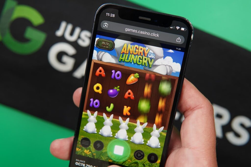 Patrik Lidin holding an iPhone with the Casino Click casino in-game mobile page loaded on the webpage.