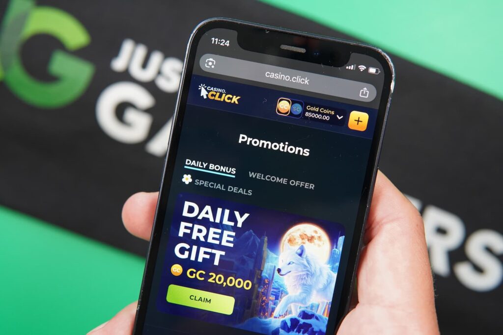 Patrik Lidin holding an iPhone with the Casino Click casino promotions page loaded on the webpage.