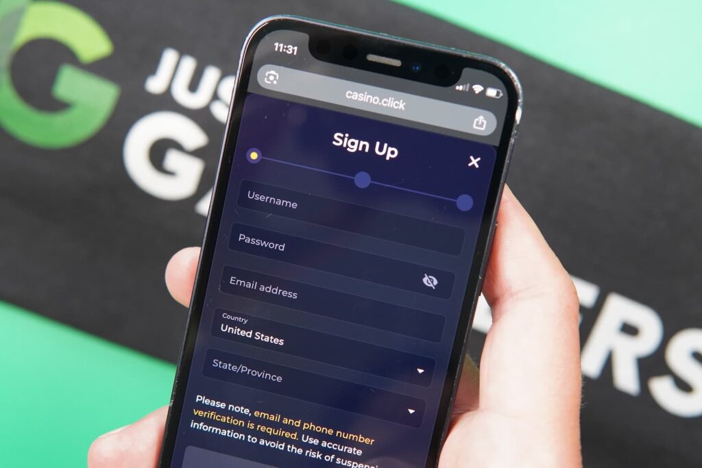Patrik Lidin holding an iPhone with the Casino Click casino registration page loaded on the webpage.