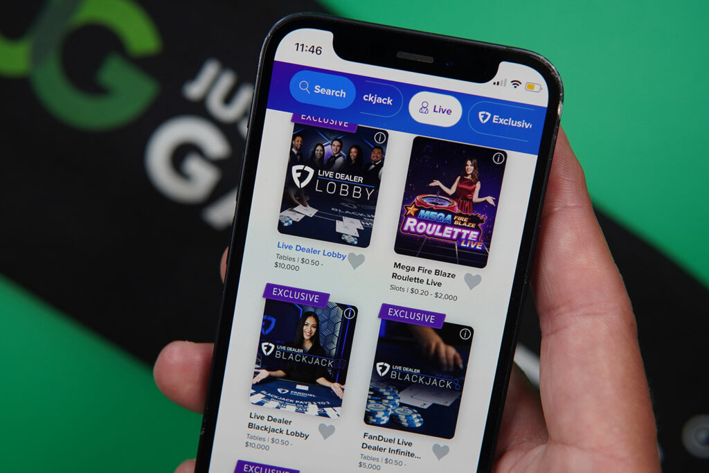 Photo of Patrik Lidin holding an iPhone with online live casino FanDuel showing.