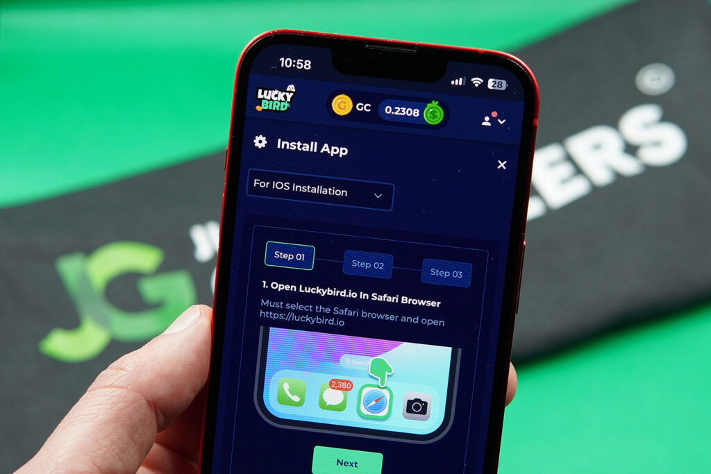 Patrik Lidin holding an iphone showing the iOS app download page of LuckyBird.io.