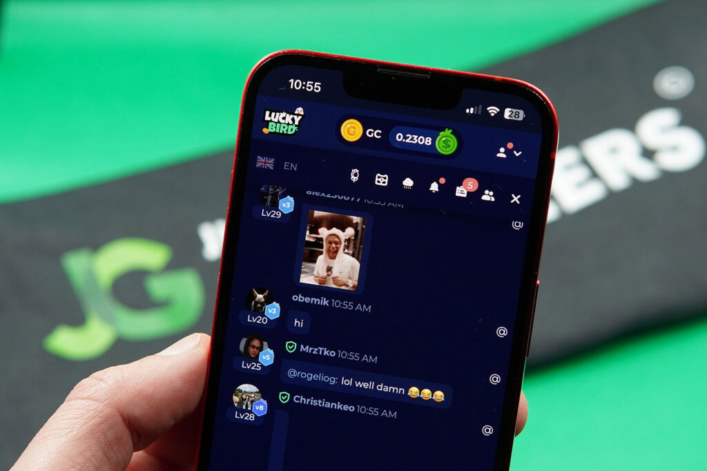 Patrik Lidin holding an iPhone while using the LuckyBird.io community chat.