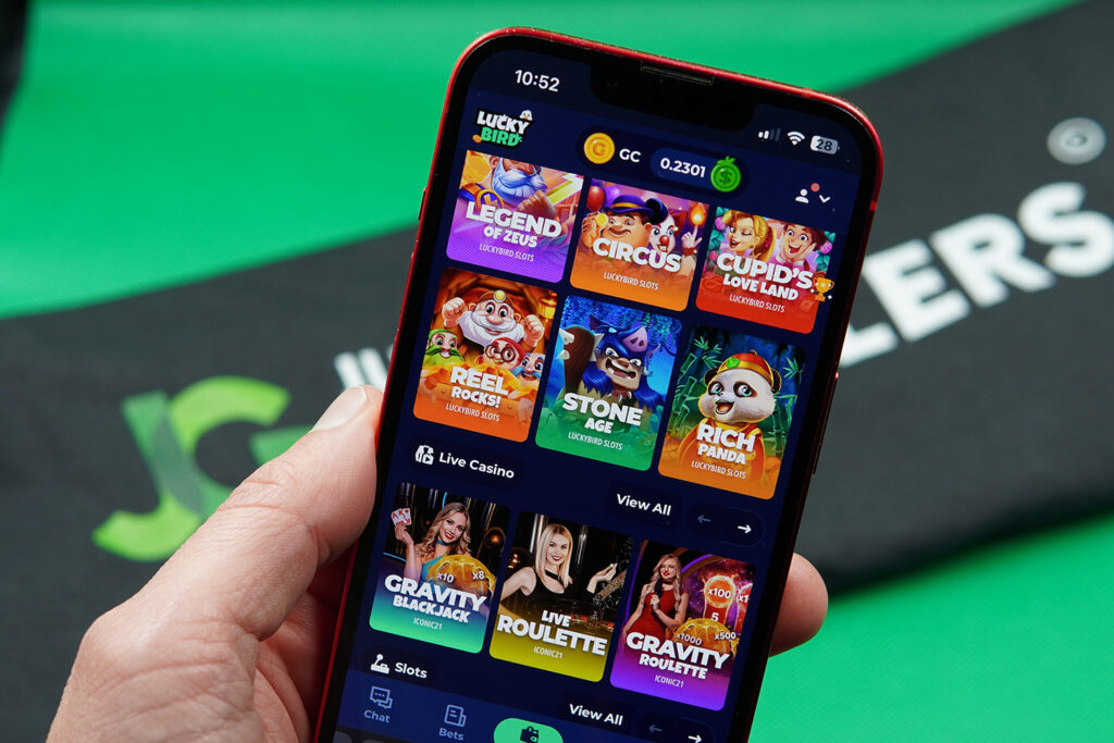 Patrik Lidin holding an iPhone with LuckyBird.io game library showing.