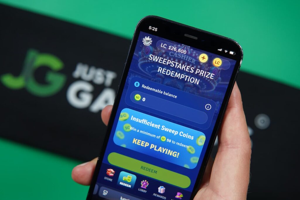 Patrik Lidin holding an iPhone with the Lunaland casino redemptions page loaded on the webpage.