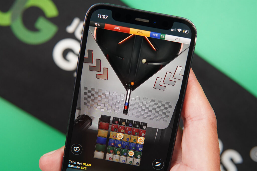 Photo of Patrik Lidin holding an iPhone showing live dealer game Marble Rush.
