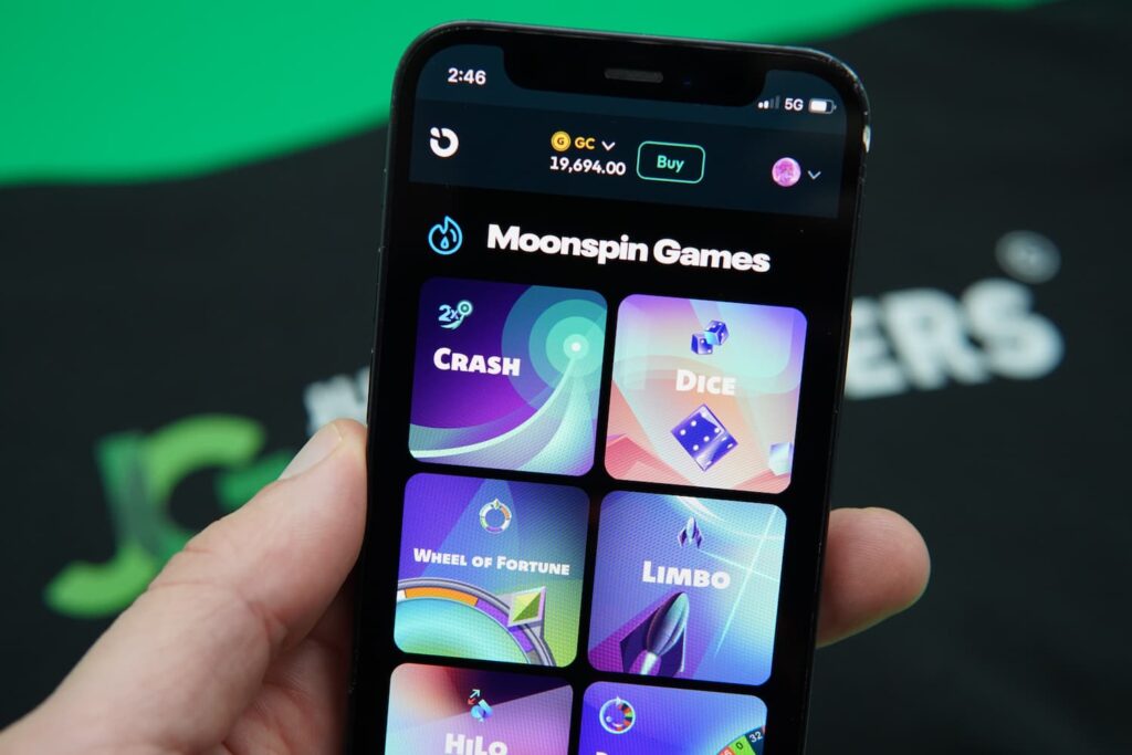 Patrik Lidin holding an iPhone with the Moonspin game library page loaded on the webpage.