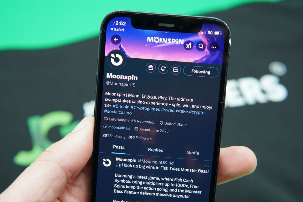 Patrik Lidin holding an iPhone with the Moonspin X page loaded on the webpage.