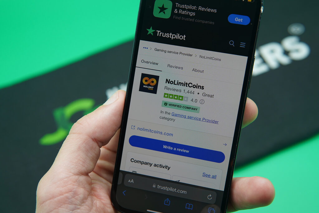 Patrik Lidin holding an iPhone showing NoLimitCoins Trustpilot rating.