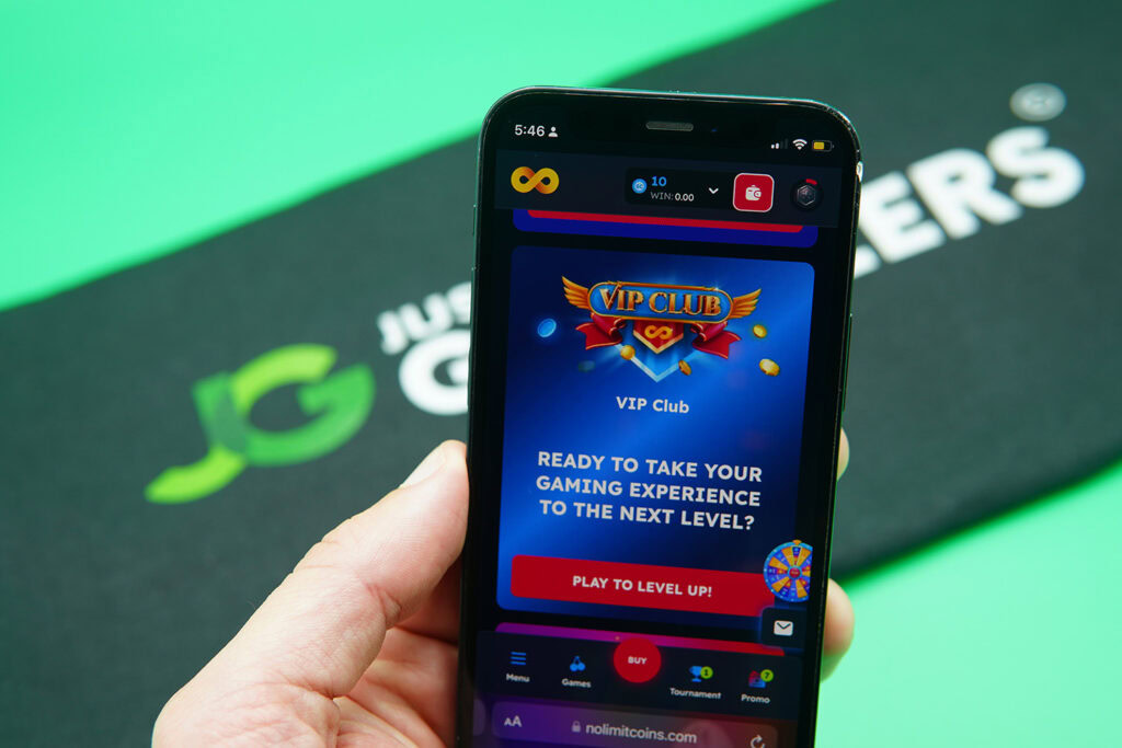 Patrik Lidin holding an iPhone showing the NoLimitCoins VIP program on the webpage.