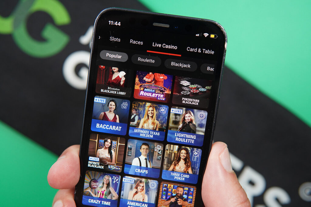 Photo of Patrik Lidin holding an iPhone with online live casino PokerStars showing.