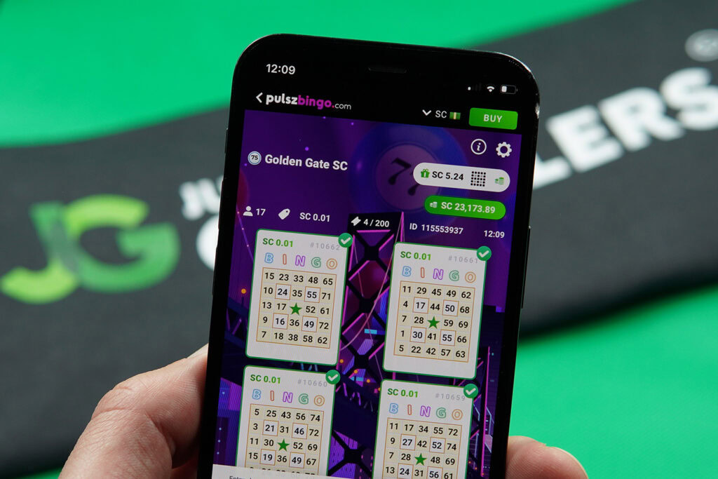 Patrik Lidin holding an iPhone with Pulsz Bingo 75-Ball bingo games showing.