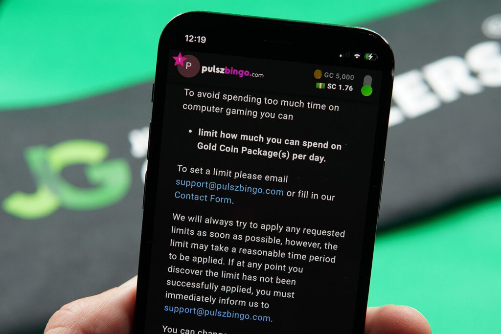 Patrik Lidin holding an iPhone with the Pulsz Bingo responsible gambling page showing.
