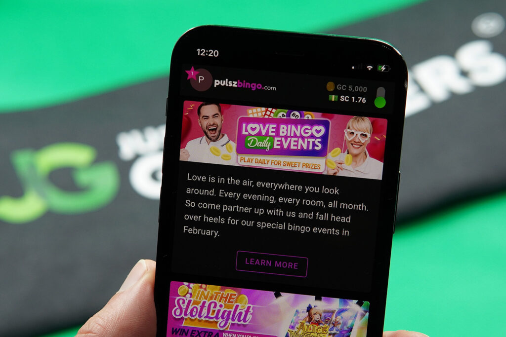 Patrik Lidin holding an iPhone with the Pulsz Bingo rewards page loaded on the webpage.