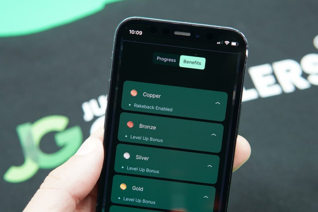 Patrik Lidin holding an iPhone with the Punt casino VIP page loaded on the webpage.