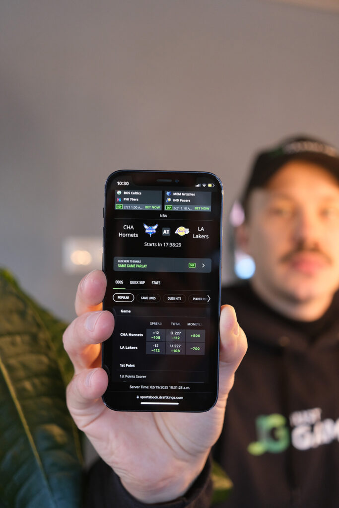 Photo of Patrik Lidin holding his iPhone while testing and reviewing the DraftKings sports betting site.
