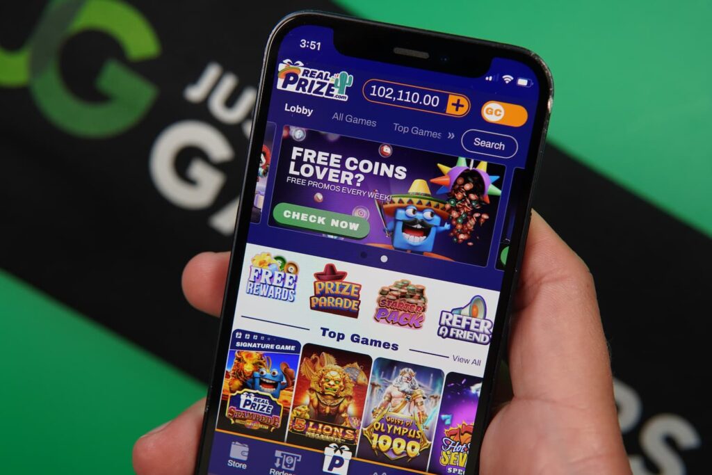 Patrik Lidin holding an iPhone with the RealPrize casino landing page loaded on the webpage.