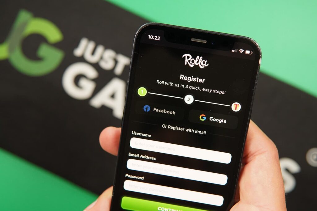 Patrik Lidin holding an iPhone with the Rolla casino registration page loaded on the webpage.