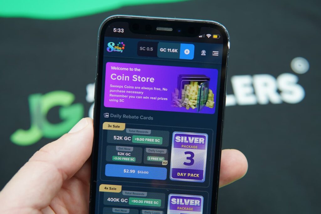 Patrik Lidin holding an iPhone with the Spin Sorcery casino coin purchase page loaded on the webpage.
