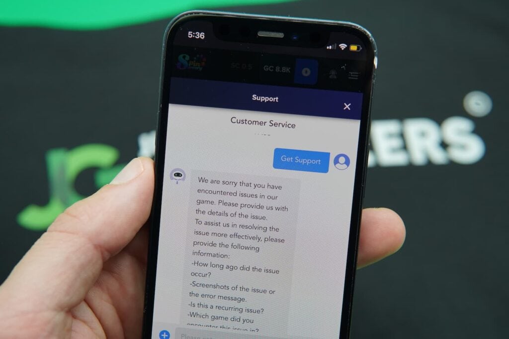 Patrik Lidin holding an iPhone with the Spin Sorcery casino support page loaded on the webpage.