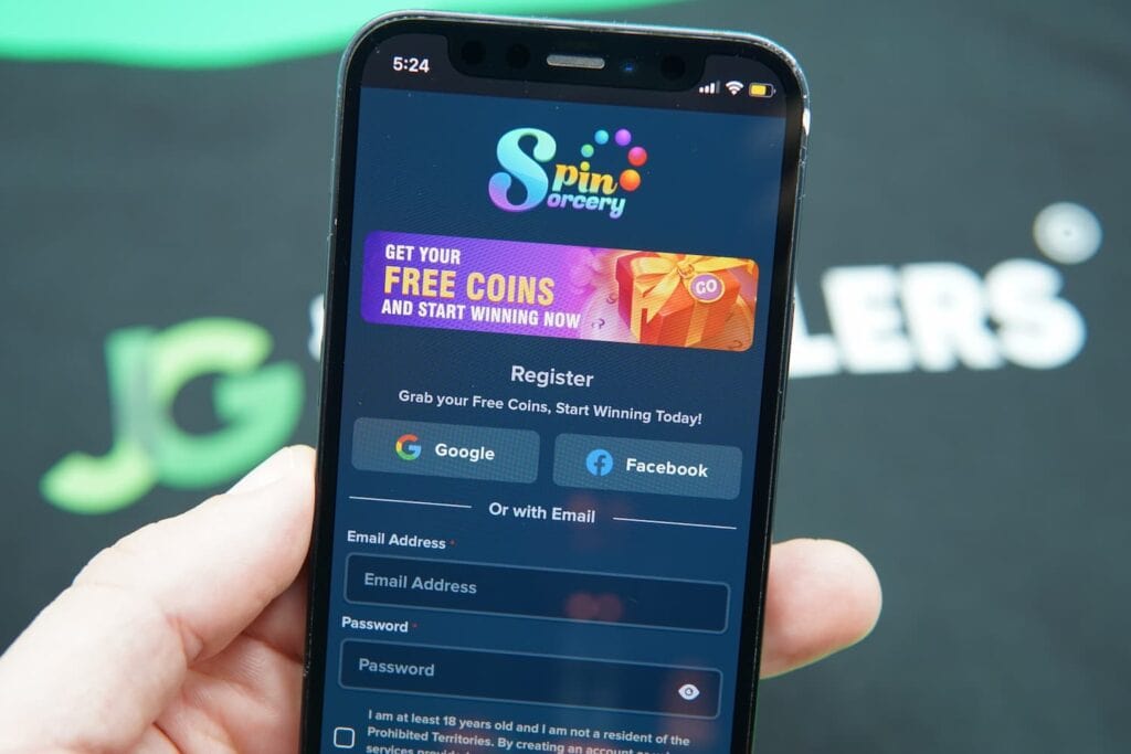 Patrik Lidin holding an iPhone with the Spin Sorcery casino registration page loaded on the webpage.