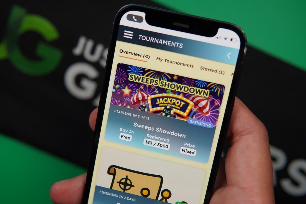Patrik Lidin holding an iPhone with the Spinfinite casino promotions page loaded on the webpage.