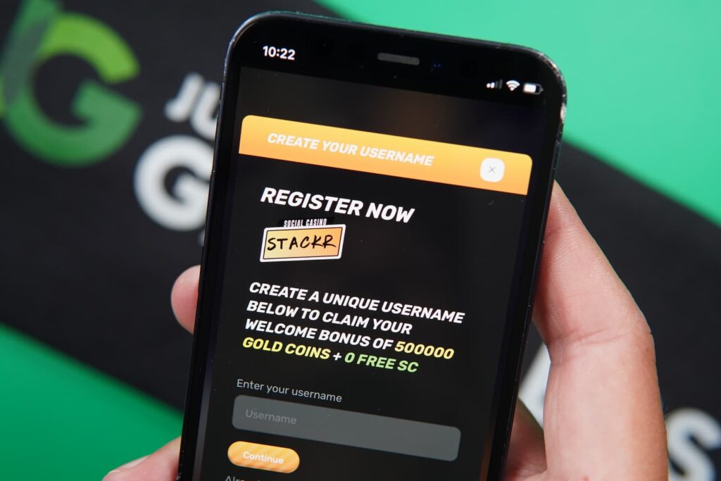 Patrik Lidin holding an iPhone with the Stackr casino registration page loaded on the webpage.