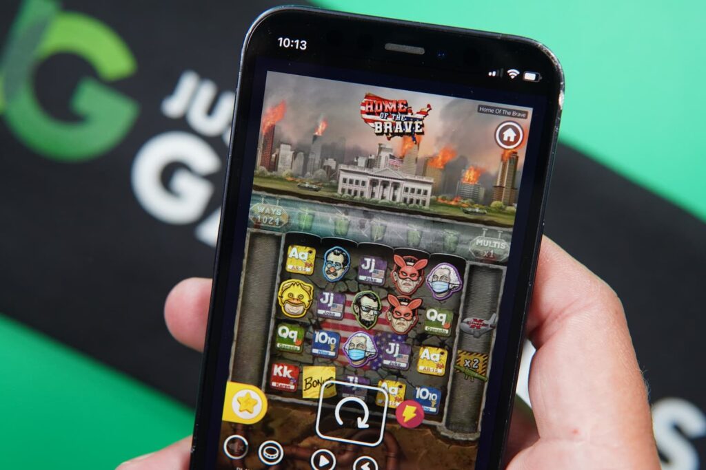 Patrik Lidin holding an iPhone with the Vegas Coins casino mobile game page loaded on the webpage.