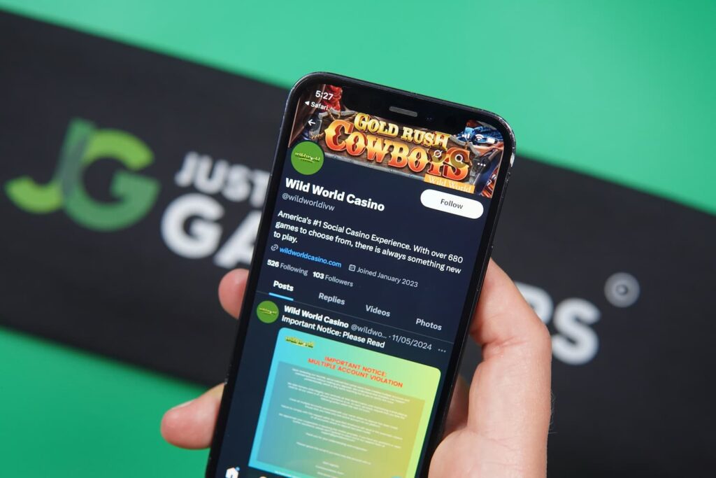 Patrik Lidin holding an iPhone with the Wild World Casino X social media page loaded on the webpage.